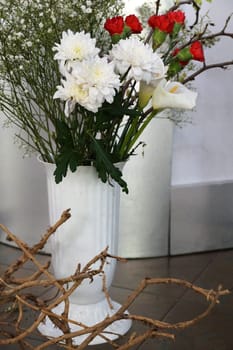 floor ikebana with a flower bouquet in a white tall vase.