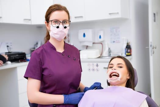Young female doctor and patient in modern dental clinic.