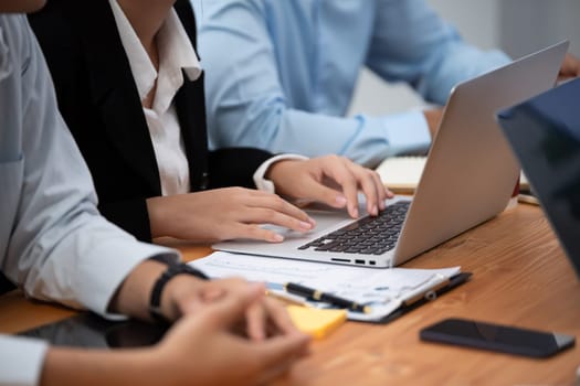 Diverse business people work together, discuss in corporate office. Professional teamwork discussing and pointing at laptop. Modern multicultural office worker. Concord