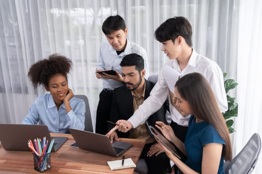 Happy diverse business people work together, discussing in corporate office. Professional and diversity teamwork discuss business plan on desk with laptop. Modern multicultural office worker. Concord