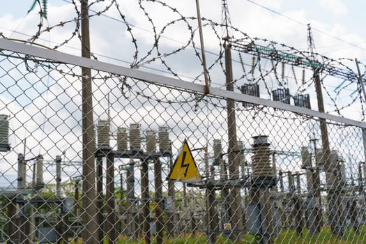 An electrical substation topped with many wires for security and containment purposes.