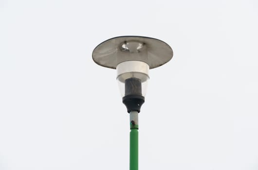 A green pole with a light fixture on top stands tall against the sky.