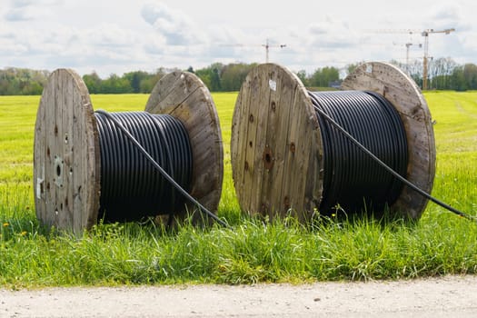 Two reels of wire are placed on the green grass.