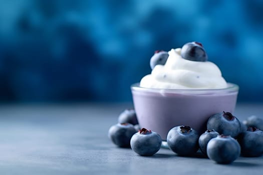 A blueberry yogurt ice cream in a white bowl surrounded by fresh blueberries.