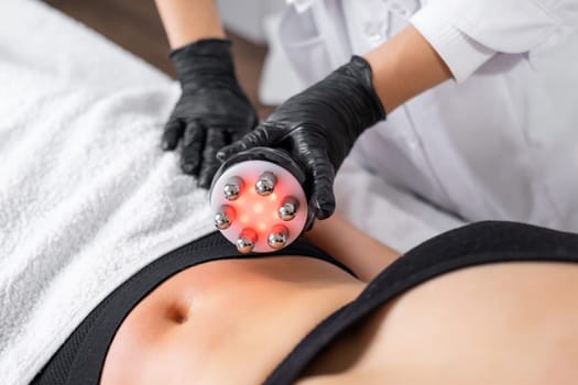 A cosmetologist expertly utilizes RF technology to conduct skin tightening and body contouring procedures to refine the abdominal area of a young woman
