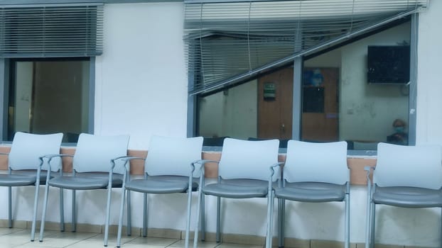 gray office chairs in the hallway near the windows, doors and tris. High quality photo