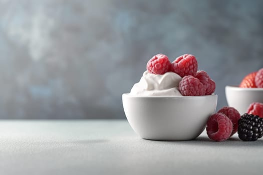 Bowl of yogurt topped with fresh raspberries on a sleek surface.
