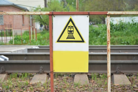 Beware of the train. A yellow triangle with a black image.