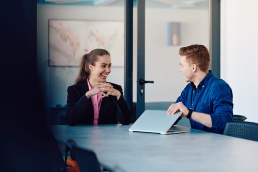 A business leader in a suit conversing with her worker in the IT industry about new business projects and existing business problems.