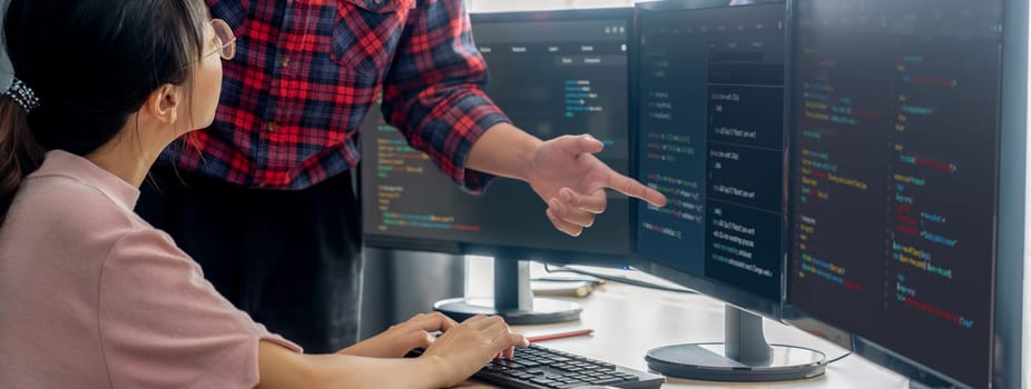 Cropped image of professional programer team collaboration discuss about web coding while coworker point java script displayed on computer at modern company office. Closeup. Burgeoning.