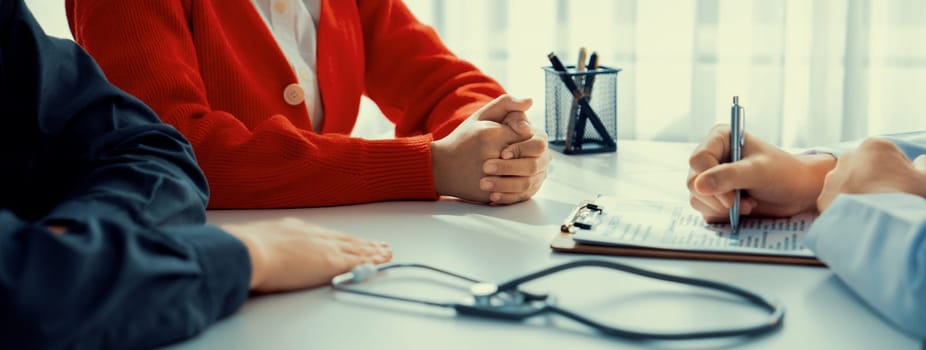 Couple attend fertility consultation with gynecologist at hospital as part family planning care for pregnancy. Loving husband and wife support each other through the doctor appointment. Panorama Rigid