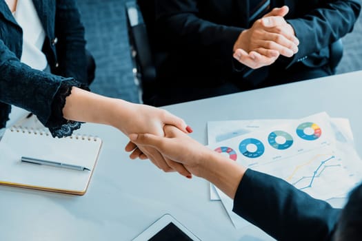 Business people agreement concept. Businessman and Asian businesswoman do handshake in the office. uds