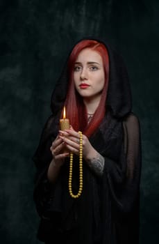 portrait of a sexy beautiful girl with red hair with a candle