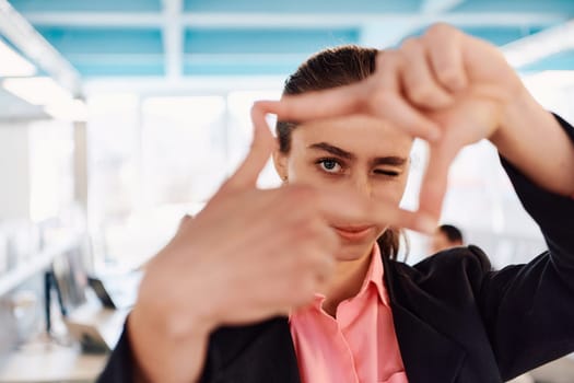 Closeup of hands, Smiling Business Woman Making Frame Gesture with at modern bright coworking open space startup office.