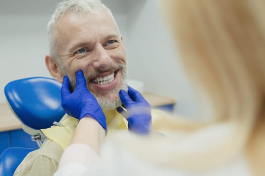 Male smiling during her dental treatment at dentist.