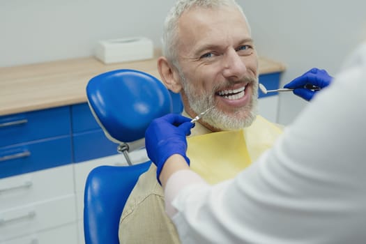 Male smiling during her dental treatment at dentist.