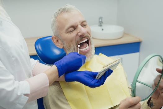 Male smiling during her dental treatment at dentist.