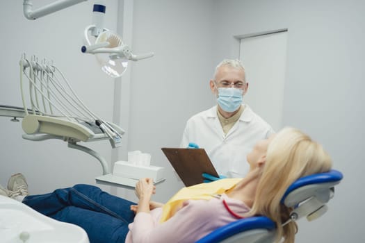 Woman smiling during her dental treatment at dentist.