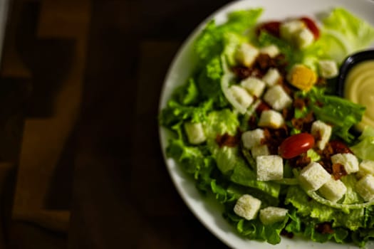 Vegetarian ceasar salad with cherry tomatoes croutons and lettuce on plate.