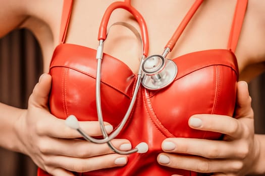 Young woman in red corset and black leather pants with a phonendoscope. Sexy brunette nurse in red and black costume with a stethoscope in her hands. Role doctor play. Entertainment