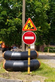 A street sign stands on the side of a rural road, providing directions to motorists and pedestrians. Vertical frame.