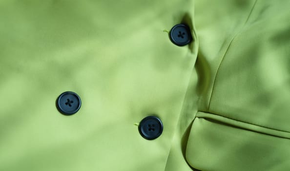 Closeup of custom made green jacket with black buttons. Strict business jacket and details