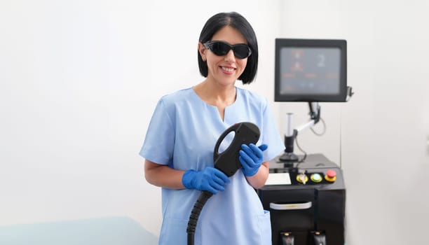 Device for laser hair removal and the hands of cosmetologist cosmetologist in medical gloves. Cosmetologist services and laser hair removal concept