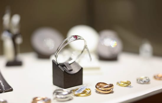 White gold ring with ruby on shop window closeup. Sale of jewelry closeup