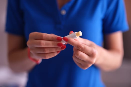 Woman with hygienic lipstick in hands closeup. Lipstick hygienic treatment and restoration of skin of lips concept