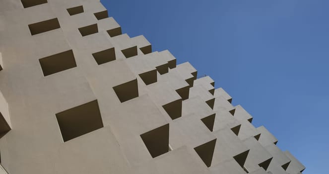 Modern facade of residential building with large balconies. View of modern concrete apartment building