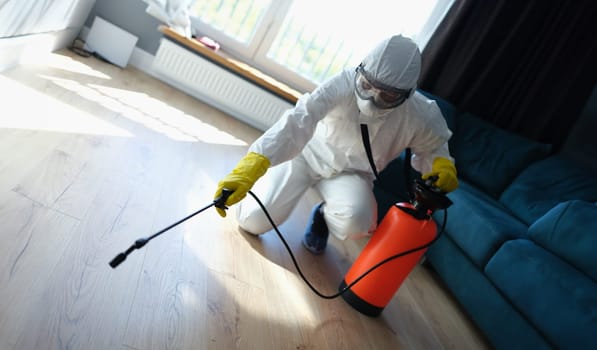 Pest and virus bacteria control contractor works in apartment. Disinfection of premises from insects and rodents with chemicals concept