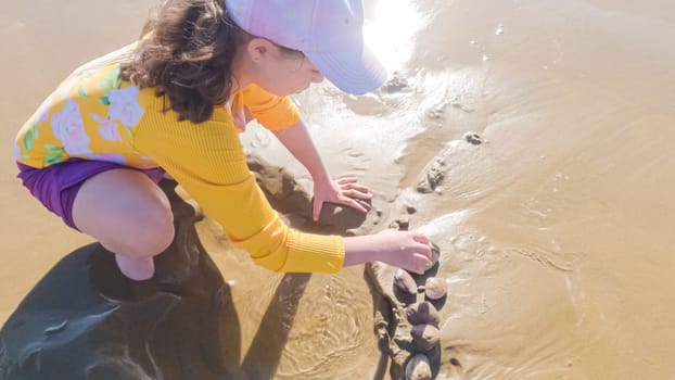 Little girl joyfully clamming on Pismo Beach, bundled up for the winter chill as she explores the sands for seashells and clams.