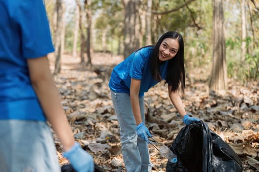 Young volunteer with garbage bag cleaning area in forest, People and ecology. Volunteer concept.