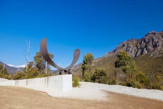 The picturesque Gordon River Rd at the Sentinel range of mountains near Bitumen Bones Sculpture on a hot summer's afternoon in Southwest National Park, Tasmania, Australia