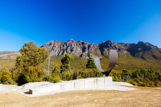 The picturesque Gordon River Rd at the Sentinel range of mountains near Bitumen Bones Sculpture on a hot summer's afternoon in Southwest National Park, Tasmania, Australia