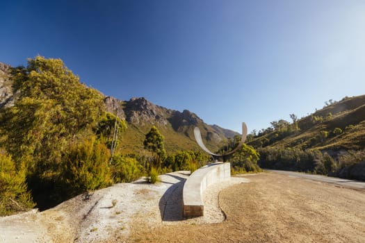 The picturesque Gordon River Rd at the Sentinel range of mountains near Bitumen Bones Sculpture on a hot summer's afternoon in Southwest National Park, Tasmania, Australia