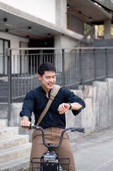 Eco friendly, Happy lifestyle asian young businessman ride bicycle go to office work at city street with bicycle in morning.