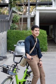 Eco friendly, Happy lifestyle asian young businessman ride bicycle go to office work at city street with bicycle in morning.
