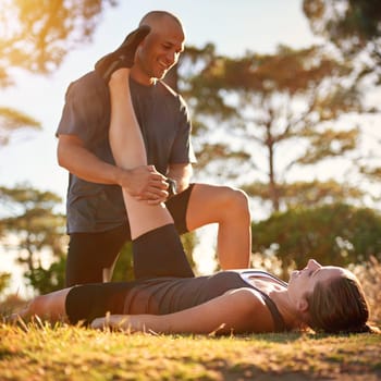 Forest, stretching and woman with man for fitness, workout coach and help for healthy body. Exercise, wellness and girl athlete with personal trainer in muscle warm up for outdoor training in morning.