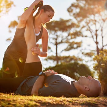 Nature, help and couple stretching for fitness, workout coach and physio for healthy body. Exercise, wellness and woman with man in muscle warm up for outdoor training in morning on forest ground