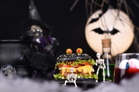 Monster Burger. Black bun, juicy beef cutlet, lettuce, onion, tomato and cheese in the shape of teeth, in the company of skeletons. Definitely a pick-me-up and a perfect Halloween party appetizer