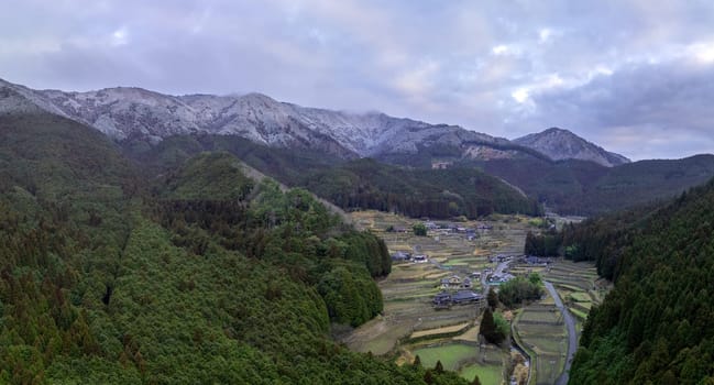 Terraced rice fields and snowy mountains in traditional Japanese village. High quality photo