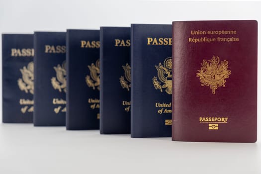 5 United States and 1 French passport transparent background. Prespective camera angle of passports marching to distance. Concept of business, trade, employment, vacation travel. Concept coming summer Olympics travel. Closeup, selective focus photo high quality photo.