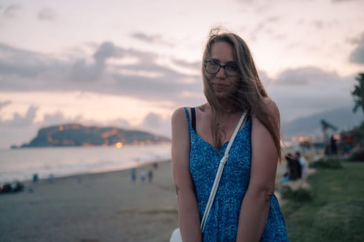 Woman sits on the beach and looks at the sea in Alanya city, Turkey. Travelling or vacation concept