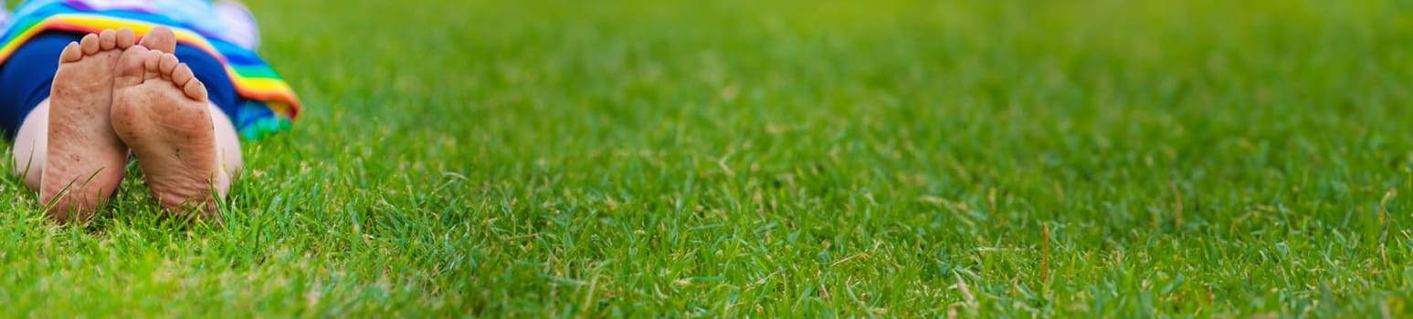 Child feet on the grass. Selective focus. Kid.