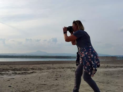 woman taking pictures of lake, solo travel.