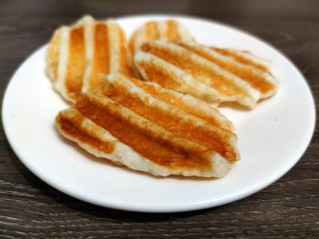 Greek halloumi cheese grilled on a white plate close-up