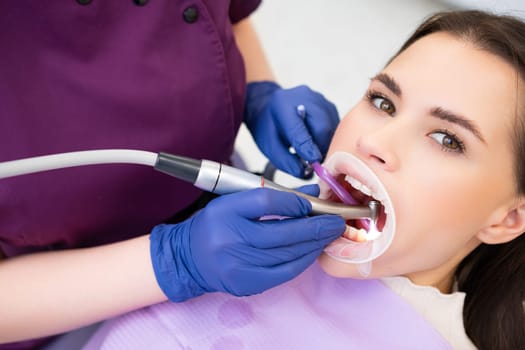 Dentist filling the tooth to the woman patient.