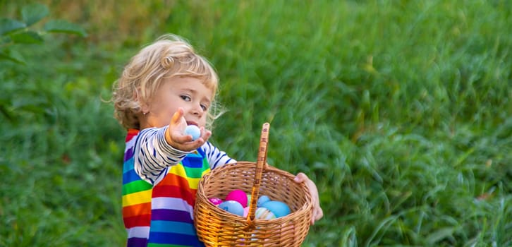 A child collects Easter eggs in the grass. Selective focus. Kid.