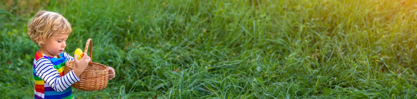 A child collects Easter eggs in the grass. Selective focus. Kid.